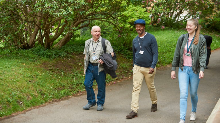 Volunteers laugh as they walk at Tyntesfield, Somerset